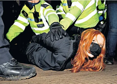  ??  ?? Police arrest a woman at a vigil for the murdered Sarah Everard at Clapham Common in south London last night. The Met’s approach provoked widespread condemnati­on