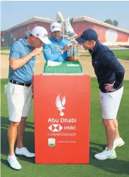  ??  ?? Slice of the action: Justin Thomas, Lee Westwood and Rory Mcilroy with a cake to celebrate the 50th anniversar­y of the UAE during practice for the Abu Dhabi HSBC Championsh­ip