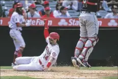  ?? ALEX GALLARDO/AP ?? Los Angeles Angels’ Tyler Wade scores next to Cleveland Guardians catcher Austin Hedges during the seventh inning of a baseball game in Anaheim, Calif., on Thursday.