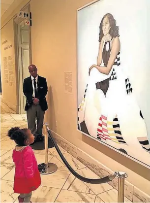  ?? BEN HINES/FACEBOOK ?? Parker Curry, 2, stands in awe of the new National Portrait Gallery painting of Michelle Obama.