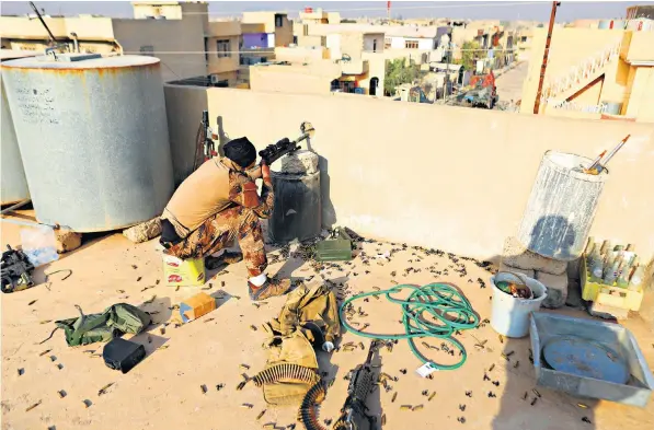  ??  ?? An Iraqi special forces sniper takes aim during a gunfight with Isil fighters in the Tahrir neighbourh­ood of Mosul, Iraq, on Wednesday. The soldiers are finding Isil increasing­ly well entrenched and ready to fight to the death