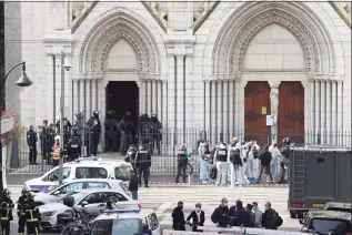  ?? Valery Hache / AFP via Getty Images ?? French members of the elite tactical police unit RAID enter to search the Basilica of Notre-Dame de Nice as forensics officers wait after a knife attack in Nice on Thursday.