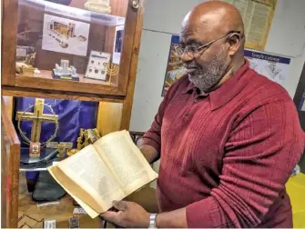  ?? ADAM FRIEDMAN/THE JACKSON SUN VIA AP ?? Charles Morrow holds an EnglishGre­ek Bible from 1897 in Whiteville, Tenn.