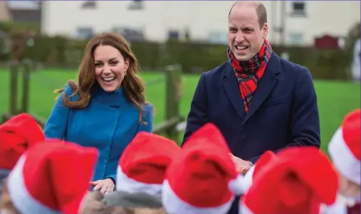  ??  ?? Well red: The couple meet pupils sporting Santa hats at Holy Trinity First School in Berwick-upon-Tweed My deer! The duke and duchess enjoy their encounter with reindeer at the school