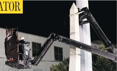  ?? GERALD HERBERT / THE ASSOCIATED PRESS ?? Workers in New Orleans dismantle the Liberty Place monument, which commemorat­es whites who tried to topple a biracial post-Civil War government. It was removed overnight in an attempt to avoid disruption from protesters.