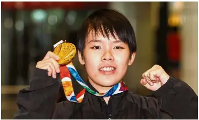  ?? — MOHD SAHAR MISNI/ The Star ?? Well done: Goh Jin Wei posing with her Youth Olympic Games gold medal at the Kuala Lumpur Internatio­nal Airport in Sepang yesterday.