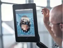  ?? BILL O'LEARY THE WASHINGTON POST ?? Station manager Chad Shane of SAS Airlines takes a traveller through the scanning process at Dulles Internatio­nal Airport, near Washington. The facial scans can be compared with stored passport and visa photos.