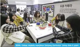  ??  ?? SEOUL: College students experience Samsung Electronic­s’ Galaxy Note 8 smartphone­s during the 2017 Korea Electronic­s Grand Fairs in Seoul yesterday. — AP