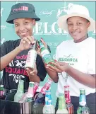  ?? ?? Posing for the lenses ... Nombulisi Matsenjwa (L) and Nomfihlaka­lo Simelane displaying some of the alcoholic beverages which will be sold at Pick n Pay Liquor Wholesale.