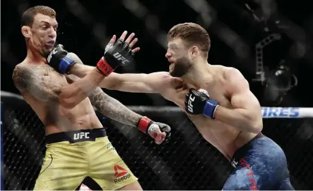  ?? AP FiLE ?? JARRING JAW SHOT: Calvin Kattar, right, punches Brazil’s Renato Moicano during a featherwei­ght mixed martial arts bout at UFC 223 in 2018 in New York. Moicano won the bout but Kattar is now the No. 6 featherwei­ght in the world with a 22-4-0 record.