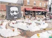  ?? JIM MONE/AP ?? A mural of George Floyd in Minneapoli­s is seen at the site that has been cordoned off near where he died May 25 after a white police officer pressed a knee on his neck for nearly nine minutes.
