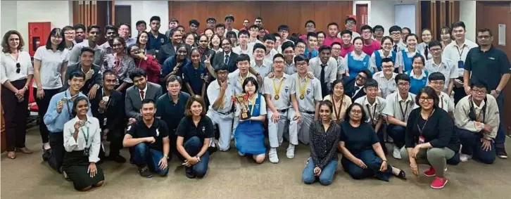  ??  ?? Members of the HELP Law Faculty together with the participan­ts from the Olympiad and champion Chong Hwa High School, Kuala Lumpur holding the trophy.