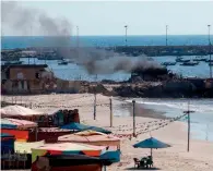  ??  ?? Smoke billows from a beach shack following the Israeli military strike on July 16, 2014, in Gaza City which killed four Palestinia­n children.