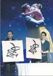  ?? FENG YONGBIN / CHINA DAILY ?? Ryan Gosling (left), the lead actor, alongside Damien Chazelle, the director, write the Chinese character ai (love) during their Beijing promotiona­l tour on Tuesday.