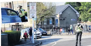  ??  ?? No go
Police monitor parking outside Lochfield Primary and (inset) an officer chats to driver