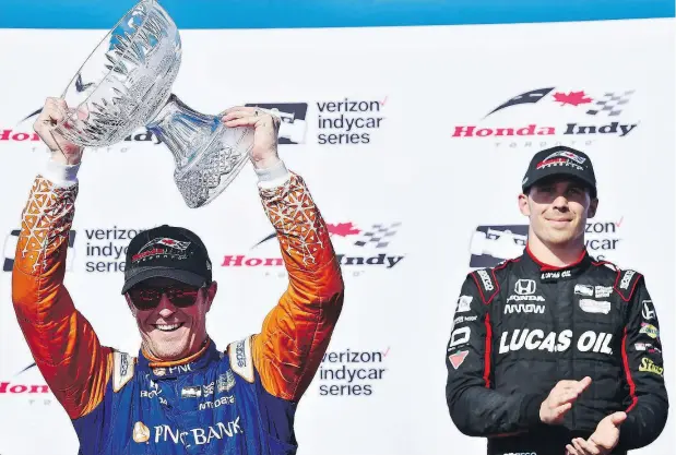  ?? FRANK GUNN / THE CANADIAN PRESS ?? Scott Dixon, left, celebrates after winning his third Toronto Honda Indy Classic on Sunday while third place finisher Robert Wickens of Guelph, Ont. looks on. The race on the 2.874-kilometre-long route featured a pair of five-car crashes that led to game-changing restarts.