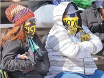  ??  ?? Janney Martinez and Greg Lucero came prepared for the wind that greeted spectators at Saturday’s New Mexico United-Denver University exhibition. Some 1,200 fans braved the elements.