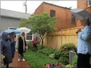  ??  ?? Pictured on the far is Phyllis Conroy, who is showing her backyard garden to guests during the 18th annual Hidden Garden Tour on Thursday.