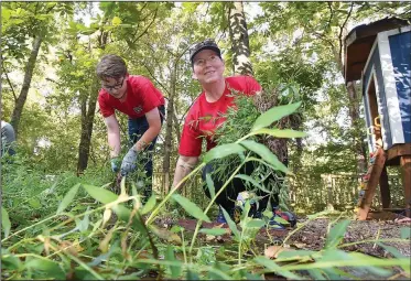  ?? NWA Democrat-Gazette/FLIP PUTTHOFF ?? Nicholas Pleiman, 14, and his mom, Jennifer Pleiman, members of the Young Men’s Service League, clear weeds Saturday at Restoratio­n Village in Little Flock.