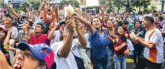  ?? FOTO AFP ?? Durante un evento religioso en Barquisime­to los asistentes recibieron alimentos. En varias partes del país se han presentado saqueos por la crisis que se vive por la falta de comida.