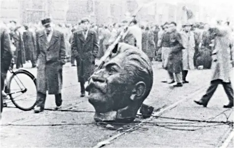  ??  ?? What goes up: the head of Stalin in Budapest in 1956, above; a painting of American soldiers pulling down a statue of George III in 1776, below