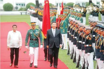  ?? — Reuters ?? Chinese President Xi Jinping and Philippine President Rodrigo Duterte inspect the honour guard before their one-on-one meeting at the Malacanang presidenti­al palace in Manila, on Tuesday.