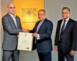  ??  ?? Ruchi Gunawarden­e, Managing Director of the Brand Finance Lanka (left) presents the certificat­e denoting the awarding of the prestigiou­s “BrandFinan­ce-Most Valuable Banking Brand title in 2019” title to BOC Chairman, President’s Counsel Ronald C. Perera and CEO/General Manager Senarath Bandara at the bank’s boardroom recently.