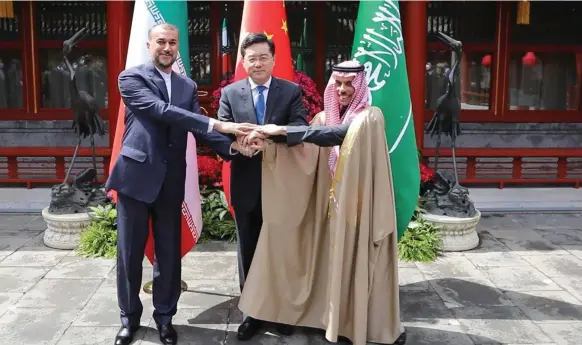  ?? EPA ?? Foreign ministers, from left, Hossein Amirabdoll­ahian of Iran, Qin Gang of China and Prince Faisal bin Farhan of Saudi Arabia, join hands in Beijing