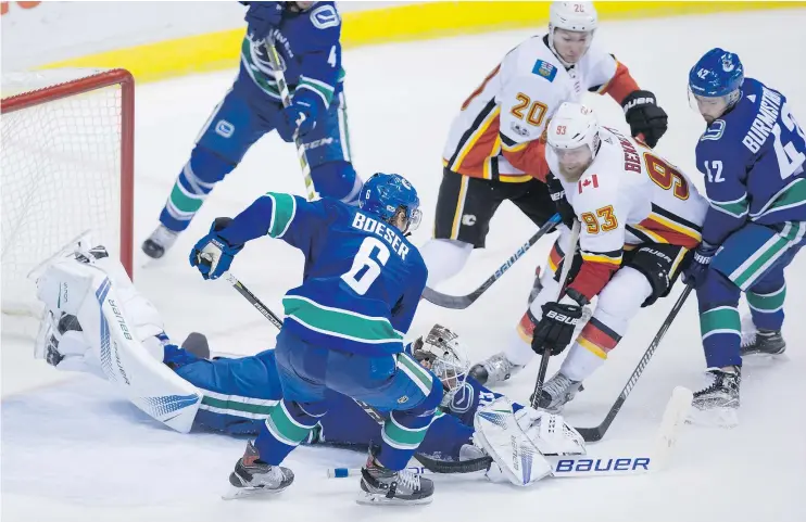  ?? — THE CANADIAN PRESS FILES ?? Canucks goalie Jacob Markstrom covers up the puck against Calgary Saturday. The Canucks play a high-risk, high-reward system that can be risky.