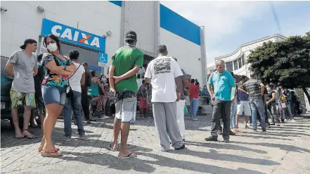  ?? ALEX SILVA/ESTADÃO ?? Auxílio. Beneficiár­ios formam fila para receber o benefício; pagamento fez crescer o índice de popularida­de do presidente