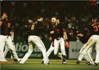  ?? Santiago Mejia / The Chronicle ?? Curt Casali and Steven Duggar celebrate after Casali’s double brought home Duggar with the winning run in the 11th inning of the Giants’ 6-5 victory over the A’s on June 26.