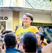  ?? — AFP ?? Brazilian right- wing presidenti­al candidate Jair Bolsonaro gestures after being stabbed in the stomach during a campaign rally in Juiz de Fora, Minas Gerais State, in Brazil, on Friday.