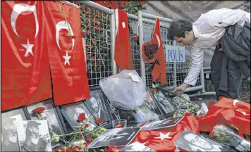  ?? EMRAH GUREL / ASSOCIATED PRESS ?? A man leaves carnations at a memorial for victims of the attack in Istanbul. A new video shows a suspect in the shooting taking a selfie in a city square.