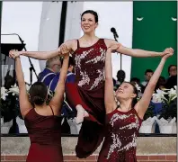  ?? Arkansas Democrat-Gazette/THOMAS METTHE ?? New Creation Dance Company of Central Arkansas members Erin Sanders (left) and Jessica Borden lift Saige Wood while performing during the 30th annual Community Easter Sunrise Service on Sunday at the Little Rock River Market.