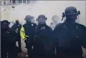  ?? JOHN MINCHILLO — THE ASSOCIATED PRESS ?? Police form a line to try to prevent rioters from storming the Capitol in Washington on Jan. 6.