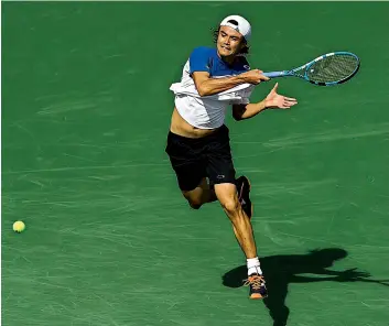  ?? — AFP ?? Taro Daniel of Japan returns the ball during his match against Novak Djokovic of Serbia in the BNP Paribas Open at the Indian Wells Tennis Garden on Sunday in Indian Wells, California (USA). Daniel, who made the main draw after fighting through the...