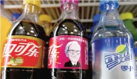  ?? — AP ?? BEIJING: A bottle of Cherry Coca-Cola with a portrait of Berkshire Hathaway Chairman and CEO Warren Buffett sits on a shelf with other soft drinks at a convenienc­e store in Beijing yesterday.