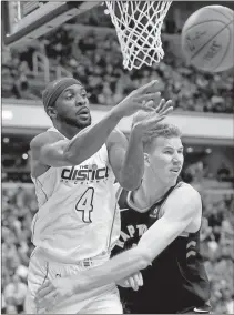  ?? Nick Wass / AP ?? Washington’s Ty Lawson (left) passes the ball against Toronto’s Jakob Poeltl in an NBA postseason first-round game. Lawson has lately been one of the first subs off the bench for the Wizards even though just three weeks ago he was playing profession­al basketball in China.