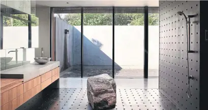  ?? MATTHEW HUFFT, ANDREW FABIN PHOTOS ?? The one-ton boulder that serves as a bench in the master ensuite shower was lowered by crane through the skylight.