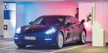  ?? DPA-BILD: AXEL HEIMKEN ?? Porsche fährt technologi­sch vorn – im Bild ein Elektro-Fahrzeug bei der automatisc­hen Aufladung. Doch der Hersteller hat Altlasten.