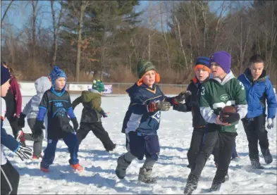  ?? PHOTOS BY LAUREN HALLIGAN - MEDIANEWS GROUP ?? Children participat­e in a game of football on Christmas Eve morning at the fourth annual Christmas Eve Bowl at Gavin Park in Wilton.