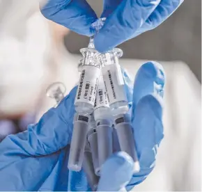  ??  ?? A staff member displays samples of the COVID-19 inactivate­d vaccine at Sinovac Biotech Ltd., in Beijing, capital of China, March 16, 2020.