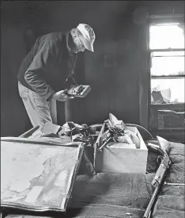  ?? ERIC ALBRECHT
DISPATCH ?? Mahalie Moore’s boyfriend, Leroy Gillam, searches Christophe­r M. Glass’ room after Glass allegedly set fire to the house on Tuesday.