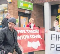  ?? Pictures: Steven Brown. ?? Top: Fife Council co-leader David Alexander speaking to protesters at a demonstrat­ion outside the Jobcentre in Glenrothes. Above left: Some of the Glenrothes activists. Above right: A demonstrat­or making his thoughts known in Dundee.