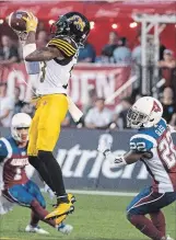  ?? PAUL CHIASSON THE CANADIAN PRESS ?? Hamilton Tiger-Cats running back Alex Green catches a pass in front of Alouettes defensive back Tyquwan Glass during first-quarter Canadian Football League action in Montreal on Friday.