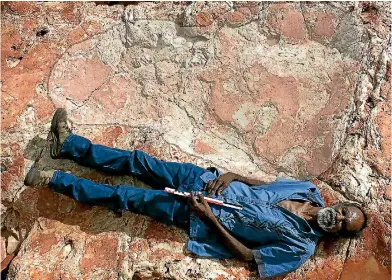  ?? PHOTO: STEVE SALISBURY ?? Richard Hunter lies next to a 1.7-metre dinosaur footprint belonging to a sauropod.