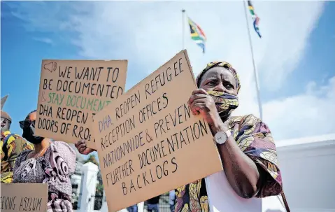  ?? | HENK KRUGER African News Agency (ANA) ?? A GROUP of foreign nationals, dressed in traditiona­l regalia, staged a demonstrat­ion on a red carpet outside Parliament yesterday. The group that represents a large number of foreign nationals in South Africa is demanding from the government the opening of all Refugee Reception Offices. In March 2020, all Refugee Reception Offices were closed after President Ramaphosa declared Covid-19 a national disaster. The group handed over a memorandum of demands to the office of Home Affairs Minister Dr Aaron Motsoaledi.