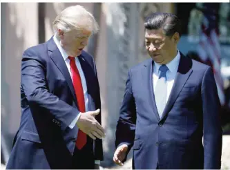  ??  ?? FLORIDA: President Donald Trump and Chinese President Xi Jinping reach to shake hands at Mar-a-Lago in Palm Beach, Florida. — AP