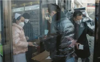  ?? GILLES SABRIE/THE NEW YORK TIMES ?? A customer purchases medicine Tuesday at a pharmacy in Beijing. Since China dropped its strict “zero-COVID” policies about two weeks ago, medication has flown off drugstore shelves across the country.