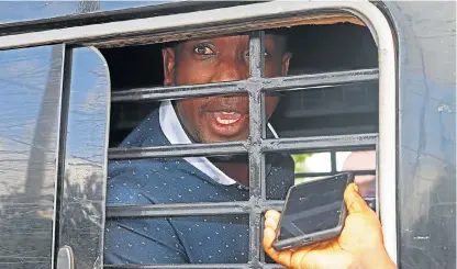  ?? /AFP ?? Assassinat­ed: Former Ugandan district police commander Muhammad Kirumira is seen in this file photograph detained in a police van as he awaits trial by a police tribunal in Kampala. Kirumira and a woman were shot and killed outside his home in the city on Saturday.